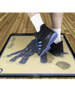 Athlete steps on adhesive sports traction mat to lift dirt from sneaker soles